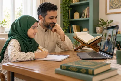 A father and daughter calmly reviewing their online Quran lesson at a small study table in a calm home study with Quran learning materials